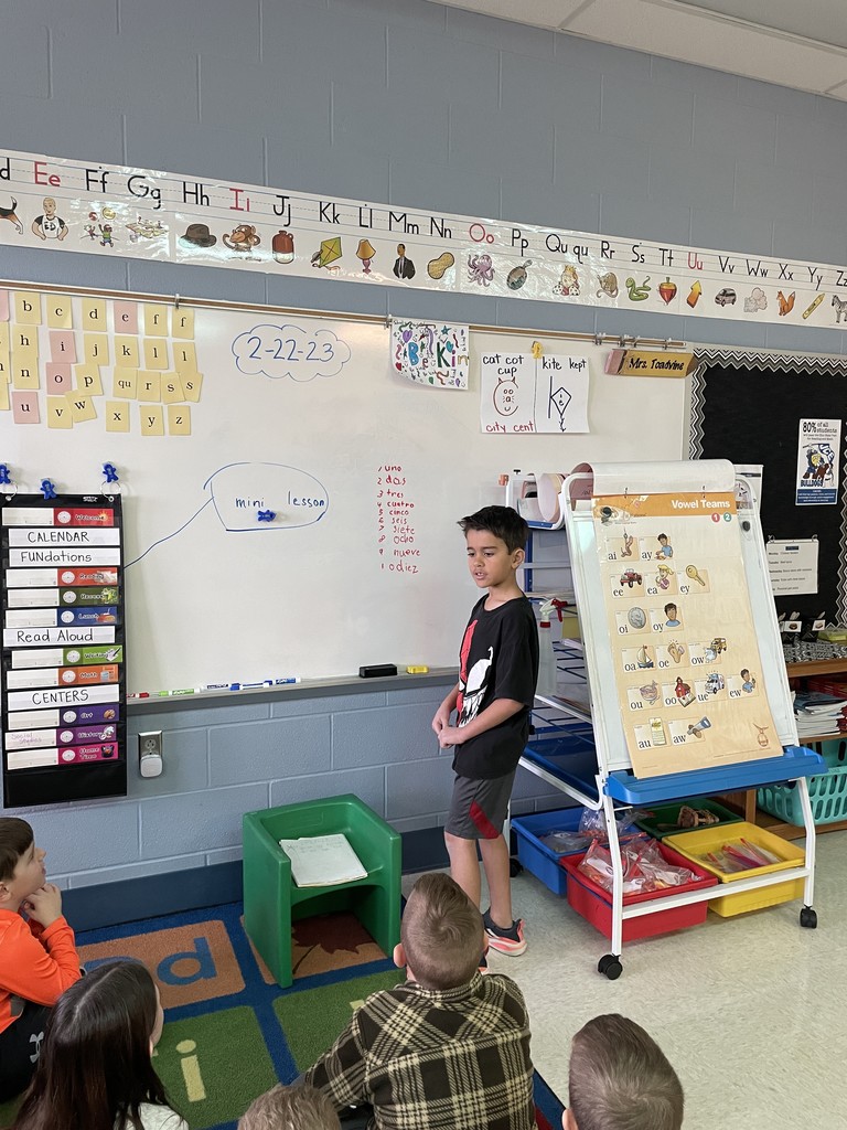 student at board teaching counting in Spanish
